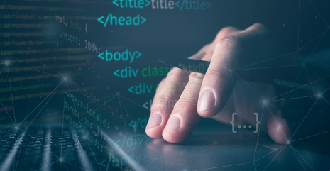 A hand on a laptop keyboard with HTML code overlaid, showing website structure such as head, body, and div elements.